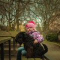 girl with his black schnauzer dog on a wooden bench Royalty Free Stock Photo