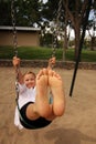 Girl with her feet together in the air swinging