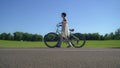 Girl hobbling with a bicycle.