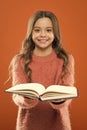 Girl hold book read story over orange background. Child enjoy reading book. Book store concept. Wonderful free childrens Royalty Free Stock Photo