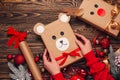 Girl hold creatively wrapped Christmas gift in the shape of a teddy bear and a deer. New Year and Christmas concept. DIY gift