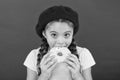 Girl hold glazed cute donut in hand red background. Kid playful girl ready to eat donut. Sweets shop and bakery concept Royalty Free Stock Photo