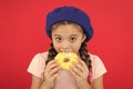 Girl hold glazed cute donut in hand red background. Kid playful girl ready to eat donut. Sweets shop and bakery concept Royalty Free Stock Photo