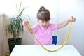 Girl hold and stretching yellow slime with golden braids on a white table. child playing with a slime toy. Making slime. Copy