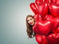 Girl holding balloons hearts. Surprised woman on white background. Surprise, valentines people and Valentine`s day concept Royalty Free Stock Photo