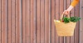 Girl holding basket with healthy organic vegetables, wooden background, copy space. Autumn harvest. Zero waste, plastic free Royalty Free Stock Photo