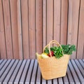 Girl holding basket with healthy organic vegetables, wooden background, copy space. Autumn harvest. Zero waste, plastic free Royalty Free Stock Photo