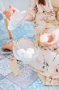 girl holding bath bombs in her hand in pink, cream and white colours on a blue background Royalty Free Stock Photo
