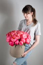 Girl holding beautiful mix coral and pink flower bouquet in round box with lid. peonies grade Coral Sharm. Royalty Free Stock Photo