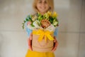 Girl holding beautiful mix flower bouquet in round box with lid Royalty Free Stock Photo