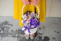 Girl holding beautiful purple bouquet of mixed flowers in basket Royalty Free Stock Photo