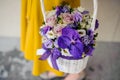 Girl holding beautiful purple bouquet of mixed flowers in basket Royalty Free Stock Photo