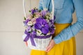 Girl holding beautiful purple bouquet of mixed flowers in basket Royalty Free Stock Photo