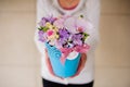 Girl holding beautiful purple bouquet of mixed flowers in vase Royalty Free Stock Photo