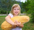 Girl holding big bread humor size hungry child Royalty Free Stock Photo
