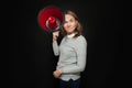 Girl holding big red bullhorn on black background. Woman with loudspeaker megaphone Royalty Free Stock Photo