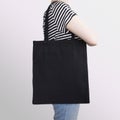 Girl is holding black cotton eco tote bag, design mockup. Royalty Free Stock Photo