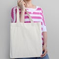 Girl is holding blank cotton eco bag, design mockup.