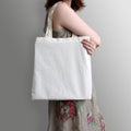 Girl is holding blank cotton eco tote bag, design mockup. Royalty Free Stock Photo