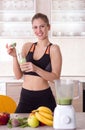 Girl holding bottle with green smoothie in kitchen Royalty Free Stock Photo