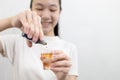 Girl holding a bottle of medicine for rinsing the mouth or gargling,dripping an antiseptic into a glass to gargle,protect against