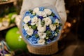 Girl holding a bouquet with blue and white flowers wrapped in matte transparent paper decorated with green leaves Royalty Free Stock Photo