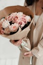 The girl is holding a bouquet of flowers. A bouquet of roses as a gift. Artificial bouquet of flowers