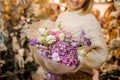 Girl holding a bouquet with pink, purple and white flowers wrapped in matte transparent paper Royalty Free Stock Photo