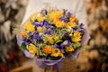 Girl holding a bouquet with purple and yellow flowers wrapped in violet paper Royalty Free Stock Photo