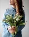 The girl is holding a bouquet of white tulips