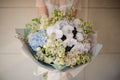 Girl holding a bouquet of white tulips, lilac, orchids and hydrangeas