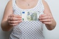 Girl is holding a brand new five euro banknote