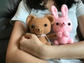 A girl holding brown teddy bear ans pink bunny crochet doll Royalty Free Stock Photo