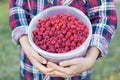 The girl is holding a bucket of ripe fresh raspberries. Royalty Free Stock Photo