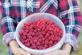 The girl is holding a bucket of ripe fresh raspberries. Royalty Free Stock Photo