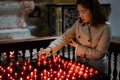 A girl is holding candle and praying near altar in church. Royalty Free Stock Photo