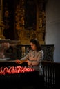 A girl is holding candle and praying near altar in church. Royalty Free Stock Photo