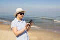 Girl holding a cellphone with sea ocean background. Royalty Free Stock Photo