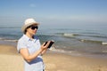 Girl holding a cellphone with sea ocean background. Royalty Free Stock Photo