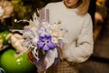 Girl holding a christmas composition with purple and white orchids and roses, tapes and candles in the box Royalty Free Stock Photo