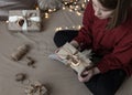 The girl is holding a Christmas gift box decorated in craft style Royalty Free Stock Photo