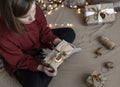 The girl is holding a Christmas gift box decorated in craft style, top view Royalty Free Stock Photo