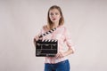 Girl is holding a clapperboard and posing. start on white background Royalty Free Stock Photo