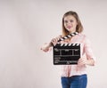 Girl is holding a clapperboard and posing. actioncutproducer start on white background Royalty Free Stock Photo