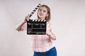 Girl is holding a clapperboard and posing. producer start on white background Royalty Free Stock Photo