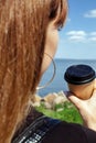 Girl holding coffee on a beautiful background. The concept of the beginning of the morning, vigor and environmental friendliness.