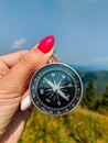 Girl holding a compass in a hand on the carpathian mountains background Royalty Free Stock Photo