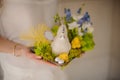 Girl holding a composition plate with white and yellow toy chicken,green moss and blue muscari