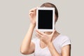 Girl holding computer pad. Mock up at tablet black screen. Face near laptop. Woman showing pc Royalty Free Stock Photo