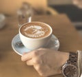 Girl holding cup of espresso latte art on table in the cafe shop